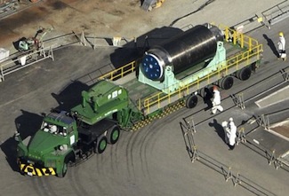 In this photo from Nov. 21, 2013, a cask containing 22 fuel rods at the Unit 4 reactor is moved via trailer to another building where a common fuel pool is located at the Fukushima Daiichi nuclear power plant. Photo by Kyodo/Reuters