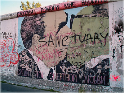 Once the announcement was made on German television, life imitated the media and chunks of the Berlin Wall became hot souvenirs as the wall was torn down. Photo by Dmitry Vrubel.