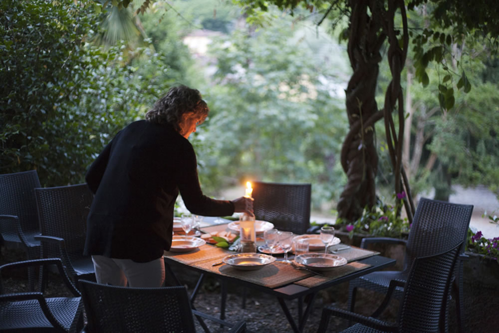 Luisa lighting a candle in Tuscany.   