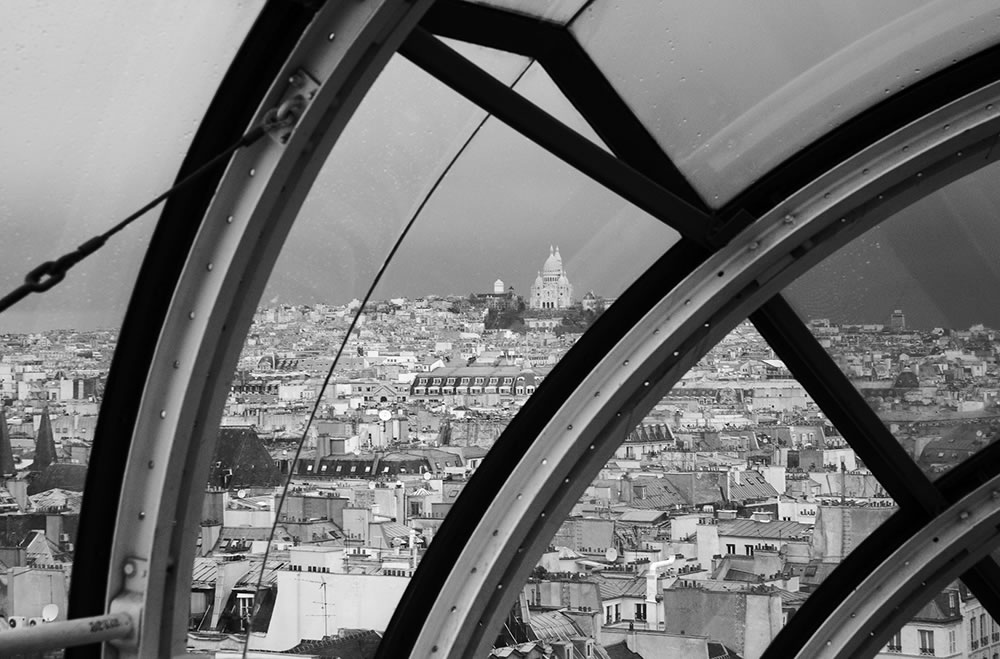 Sacre Coeur (Sacred Heart) Basilica, on top of Montmartre, as seen from the escalator tube going up the front of Centre Georges Pompidou. 