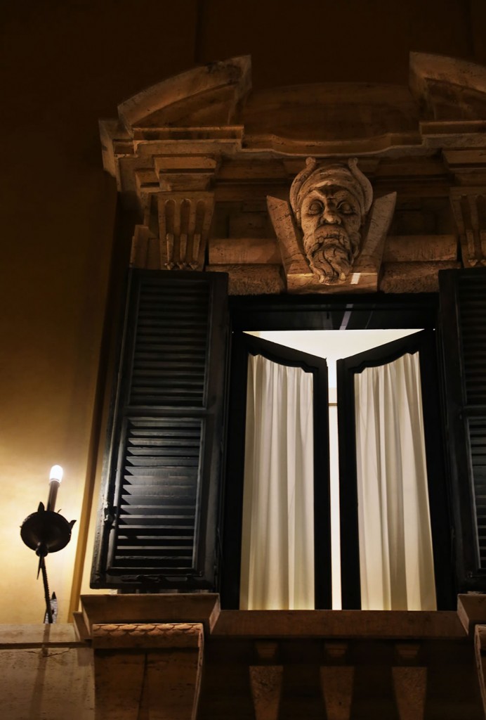 Standing guard over an open window in Rome.