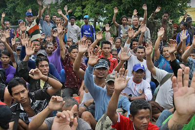 Rescued Burmese fishermen raise their hands as they are asked who among them wants to go home at the compound of Pusaka Benjina Resources fishing company in Benjina, Aru Islands, Indonesia, April 3, 2015. Photo by Dita Alangkara / AP
