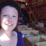 Marcy in the amazing warehouse filled with clothing, shoes, toiletries, and snacks sent or purchased by private donors. Humanity lives in every box, piled high to the giant ceiling. Photo by Marcy Franck.