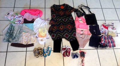 An example of what's inside a bag for a family with a mom and three kids. It's a mix of newly purchased and gently worn items. I've heard there's never enough underwear and that a purse is valuable because you can keep your most important things safe from theft. But those itty bitty baby shoes....squee! Photo by Marcy Franck.