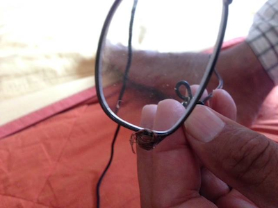 His broken glasses, held together by thread. Photo by Marcy Franck.
