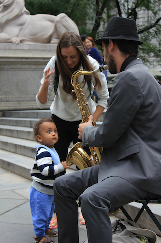 Total presence: baby and saxophonist connect in front of the New York City Library in Sept. 2014. Photo by Amanda Painter.