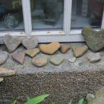 Collection of heart-shaped rocks outside the window, electronics collection inside the window; Stromness, Orkney, Scotland. Photo by Amanda Painter.